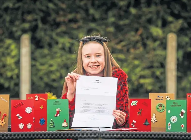  ??  ?? BIG SURPRISE: Catherine Letford, 8, with her letter from the royal couple and some of the Christmas cards she made. Picture by Mhairi Edwards.