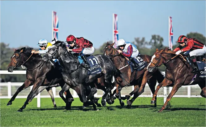  ??  ?? Pride of pack: Oisin Murphy powers Roaring Lion (No 11) to victory in the Queen Elizabeth II Stakes and, below, winning trainer John Gosden receives the trophy from the Queen