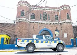  ?? ?? A police patrol car passes the Tower Street Adult Correction­al Centre in downtown Kingston, yesterday. Dancehall artiste Vybz Kartel has been housed at the facility since his murder conviction in 2014.