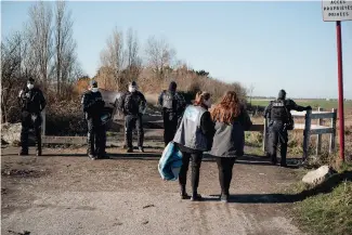  ?? ?? Emma et Ada, de Human Rights Observers, lors d’une opération de « mise à l’abri » à Calais. La police les bloque à l’écart de l’action pour les empêcher de filmer.