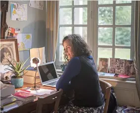  ??  ?? Agnès Desarthe dans son bureau, face à son ordinateur. Ci-contre, sa chatte Vénus et le majestueux piano.