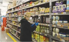  ?? (Marc Israel Sellem/The Jerusalem Post) ?? A SHOPPER examines an item at a supermarke­t last year.