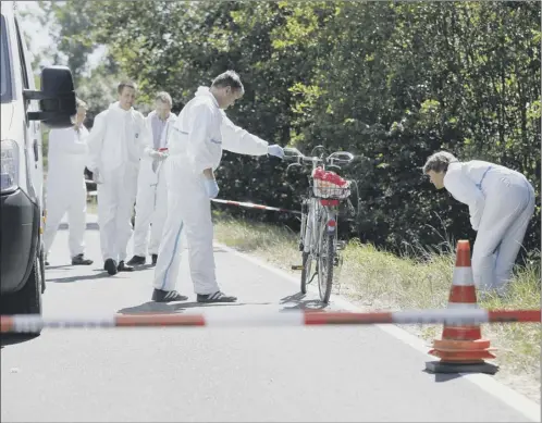  ?? Picture: AP ?? Forensic experts examine a bicycle that belonged to a man who was shot by a gunman in Rammersdor­f, Germany