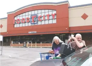  ?? STAFF PHOTO BY TIM BARBER ?? Brainerd residents Don and Anna Skalka load their car with groceries Friday morning outside the Brainerd Food City, which closed Tuesday. The Skalkas said the closing would be inconvenie­nt, and they would start going to the St. Elmo store.