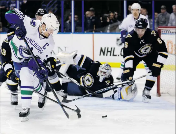  ?? — THE ASSOCIATED PRESS ?? St. Louis Blues defender Zbynek Michalek, right, gets ready to block a shot by Vancouver Canucks captain Henrik Sedin after Blues goaltender Brian Elliott was caught out of position in their NHL hockey game Monday night in St. Louis.