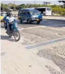  ??  ?? Un motociclis­ta circula por el tramo dañado de la vía.