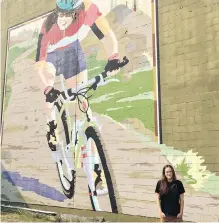  ??  ?? Lea McCroy, 17, stands in front of a mural in Canmore, Alta., in memory of her mom, Isabelle Dubé.