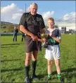  ??  ?? Referee Philip Bracken presents Bray captain Shane Baguley with the cup.