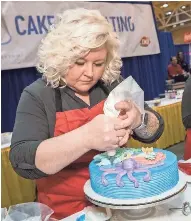  ??  ?? Candice Gumm, Appleton, decorates a cake during Dairy Queen’s biennial contest held in January to name the company’s top cake decorator.