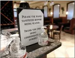  ?? BEN HASTY — MEDIANEWS GROUP ?? A sign that reads “Please use hand sanitizer before being seated. Thank you for being considerat­e of others!” next to two bottles of hand sanitizer at