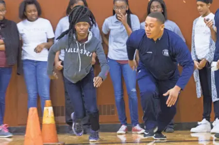  ?? MARK HOFFMAN / MILWAUKEE JOURNAL SENTINEL ?? Seventh-grader Precious Dean (left) gets coaching in an agility drill from Milwaukee police recruit Martinese McDaniel on Friday.
