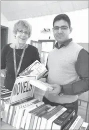  ?? MATTHEW MCCULLY ?? Book sale organizer Lissa Mcrae with committee member Ahmad Hamdan, setting up for this year’s fundraisin­g sale for the Bishop’s/champlain Refugee Student Sponsorshi­p project.