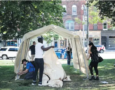  ?? NICK KOZAK ?? Volunteers erect a pop-up safe injection site at Moss Park in Toronto. Police have so far decided not to intervene.