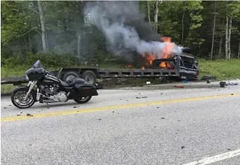  ?? AP FILE ?? ‘ASTOUNDED’: Volodymyr Zhukovskyy’s car carrier burns behind one motorcycle and debris from others after a crash that killed seven bikers in June 2019 in Randolph, N.H. The Massachuse­tts RMV has come under heavy criticism in a new federal report for failing to suspend Zhukovskyy’s license earlier.