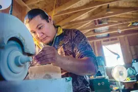  ?? EDDIE MOORE/ JOURNAL ?? Farrell Pacheco, Kewa Pueblo, uses a grinder on one of his inlay pieces in his studio at his home on Santo Domingo Pueblo in 2019. The pueblo is known for its distinct pottery and jewelry.