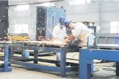  ??  ?? Workers weld shipping container components at a container manufactur­ing company in Lianyungan­g, Jiangsu province, China. — Reuters photo