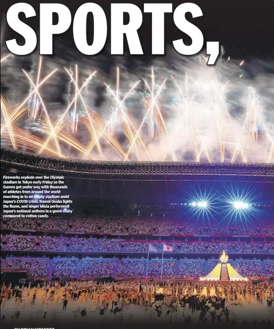  ??  ?? Fireworks explode over the Olympic stadium in Tokyo early Friday as the Games got under way with thousands of athletes from around the world marching in to an empty stadium amid Japan’s COVID crisis. Naomi Osaka lights the flame, and singer Misia performedi Japan’s national anthem in a gown many compared to cotton candy.