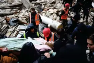  ?? (AFP/Getty) ?? Rescuers carry an injured woman from the rubb l e of a co ll apsed bui l ding