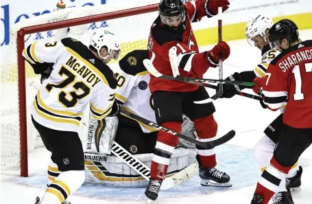  ?? GETTy imAgES; TOp, STuART CAHiLL / HERALD STAFF FiLE ?? HIGH EXPECTATIO­NS: Bruins goalie Tuukka Rask and defenseman Charlie McAvoy are unable to stop a shot by Ty Smith of the New Jersey Devils during the season-opener Thursday in Newark, N.J. McAvoy, also seen at top, is hoping to take the next step this season with veteran and longtime captain Zdeno Chara now with Washington.