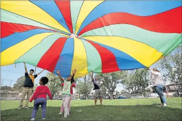  ?? FILE PHOTO ?? Children play underneath a parachute during the Earth Day Festival in Alameda in 2016. The event featured exhibits, entertainm­ent and youth activities.