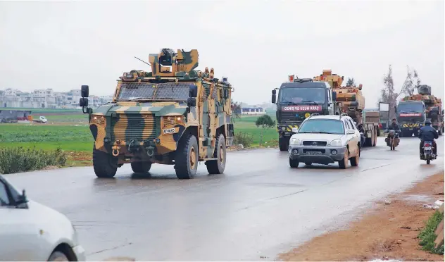  ??  ?? ↑
A military convoy drives through a highway, linking Idlib to the Bab Al Hawa border crossing, in Idlib on Wednesday.
Agence France-presse