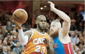  ??  ?? LeBron James, de los Cavaliers de Cleveland, pasa el balón ante lal presión defensiva de Aron Baynes, de los Pistons de Detroit.