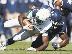  ?? Michael Dwyer / Associated Press ?? UConn defensive lineman Kevon Jones (48) tackles South Florida running back Jordan Cronkrite during the first half in East Hartford on Saturday.