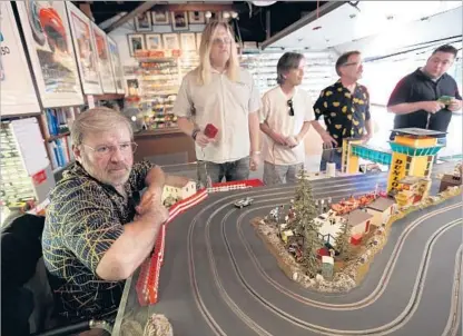  ?? Photograph­s by Marcus Yam Los Angeles Times ?? SLOT CAR racing hobbyist Michael Smalley, left, joins others competing at Stephen Farr-Jones’ home in Glendale.