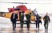  ?? JONTHAN HAYWARD THE CANADIAN PRESS ?? CFL commission­er Randy Ambrosie, far left, looks on as the Grey Cup arrives at Canadian Forces Base Edmonton.