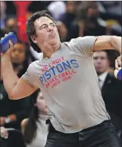  ?? Gregory Shamus Getty Images ?? TOM GORES tosses T-shirts at a 2016 Pistons game. He has been praised for his commitment to Detroit.