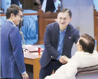  ??  ?? Sen. Bong Go shakes hands with Senate Minority Leader Franklin Drilon during deliberati­ons on the proposed P15.5-billion budget of the Bases Conversion Developmen­t Authority at the Senate yesterday. Looking on is BCDA president and CEO Vince Dizon.