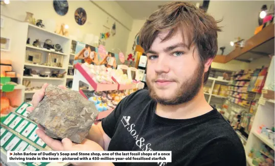  ??  ?? >
John Barlow of Dudley’s Soap and Stone shop, one of the last fossil shops of a once thriving trade in the town – pictured with a 450-million-year-old fossilised starfish