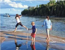  ?? KRISTEN JORDAN SHAMUS, DETROIT FREE PRESS ?? Sarah Shamus leaps on the sand as she frolics in Lake Champlain with her brother, Sam, and sister, Julia, last September.