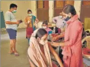  ?? PARVEEN KUMAR/HT ?? A health worker administer­s dose of Covid vaccine to beneficiar­y at a government school in Gurugram on Tuesday.