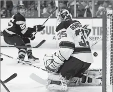  ?? MICHAEL DWYER/AP PHOTO ?? Boston’s Brandon Carlo, left, scores on New Jersey’s Cory Schneider on Saturday during the second period at the TD Garden.