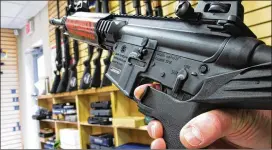  ?? ASSOCIATED PRESS ?? A gunshop employee demonstrat­es a “bump” stock. The Las Vegas gunman who fired hundreds of rounds Sunday attached the device to two of his weapons.