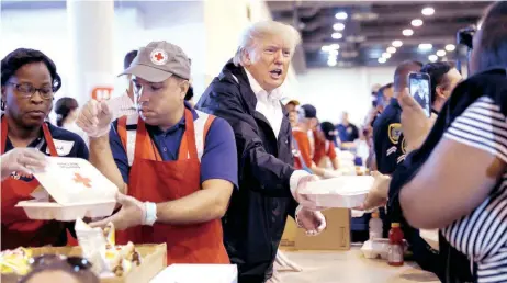  ??  ?? El presidente Donald Trump repartió ayer comida a las personas que están en uno de los refugios en Houston, Texas.