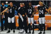  ?? PHOTO BY HARRY HOW — GETTY IMAGES ?? Las Vegas Raiders’ Derek Carr (4), head coach Jon Gruden, Trayvon Mullen (27) and Johnathan Abram (24) link arms for the National Anthem prior to a game against the Miami Dolphins at Allegiant Stadium on Saturday in Las Vegas.