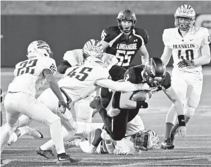  ?? AMY DAVIS/BALTIMORE SUN ?? Franklin’s Daniel Yarborough (22), Daymon David (45) and Robert Garrett (40) close in on Liganore quarterbac­k Ryan Leyh near the end of the first half of the Class 3A state football championsh­ip game at the Navy-Marine Corps Memorial Stadium on Thursday night.