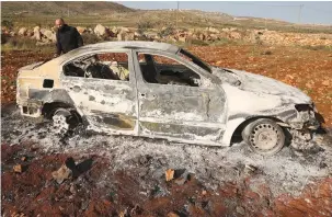  ?? (Jaafar Ashtiyeh/AFP via Getty Images) ?? A PALESTINIA­N man checks a charred car after it was allegedly set on fire by settlers in the village of Akraba, east of Nablus, yesterday.