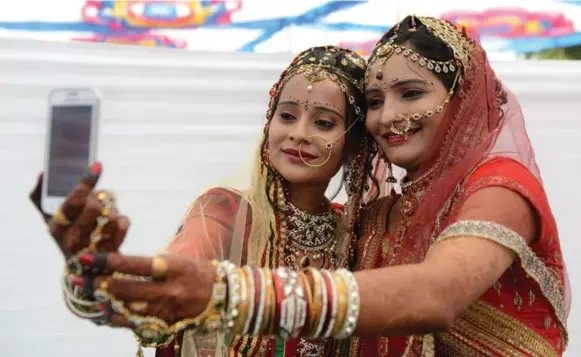  ?? SAM PANTHAKY/AFP/GETTY IMAGES ?? Single Indian women and men are increasing­ly turning to online matrimonia­l sites, but scores of women complain of men using the sites with less than noble intentions.