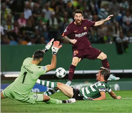  ?? — AP ?? Under threat: Barcelona’s Lionel Messi taking a shot at goal in the Champions League match against Sporting Lisbon on Wednesday.