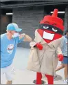  ?? CHRIS SWEDA/CHICAGO TRIBUNE ?? A Chicago Dogs fan elbows the Ketchup mascot during the home opener for the Dogs Tuesday at Impact Field in Rosemont.