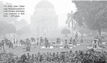  ??  ?? File photo shows Indian yoga enthusiast­s practice in Lodhi Gardens amid heavy smog conditions in New Delhi. — AFP photo