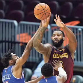  ?? Tony Dejak / Associated Press ?? Cleveland Cavaliers’ Andre Drummond (3) passes the ball over New York Knicks’ Immanuel Quickley (5) and RJ Barrett (9) during the second half on Friday in Cleveland. Cleveland won 106-103.