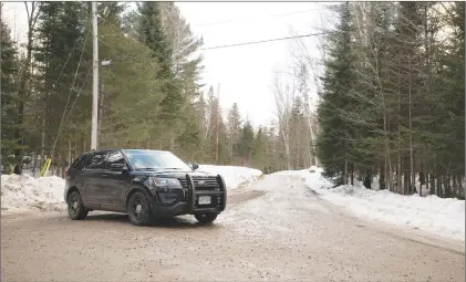  ?? CP PHOTO ?? An Ontario Provincial Police cruiser blocks the scene of what police are investigat­ing as a triple murder-suicide about 300 kilometres north of Toronto, in Ryerson Township, Ont., on Sunday.