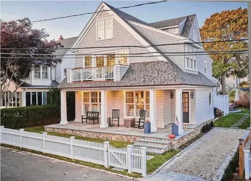  ?? Dennis M. Carbo Photograph­y/ Contribute­d photo ?? A simpler roofline and a welcoming front porch and second-story balcony are a coastal treat for the eyes.