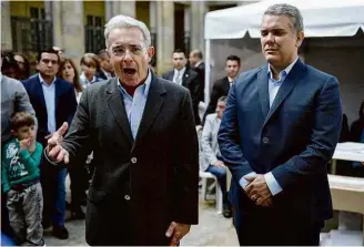  ?? Raúl Arboleda/AFP ?? O ex-presidente Álvaro Uribe fala ao lado de seu presidenci­ável, Iván Duque, após votar