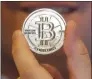  ?? Associated Press photo ?? A man holds a 25 Bitcoin token in Sandy, Utah in this 2013 file photo.