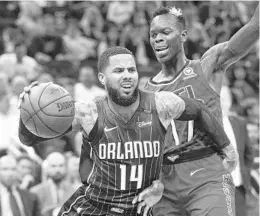  ?? REINHOLD MATAY/ASSOCIATED PRESS ?? Magic PG D.J. Augustin’s ability to knock down 3-pointers helps him create the space he needs to drive to the basket against defenders like the Hawks’ Dennis Schroder.